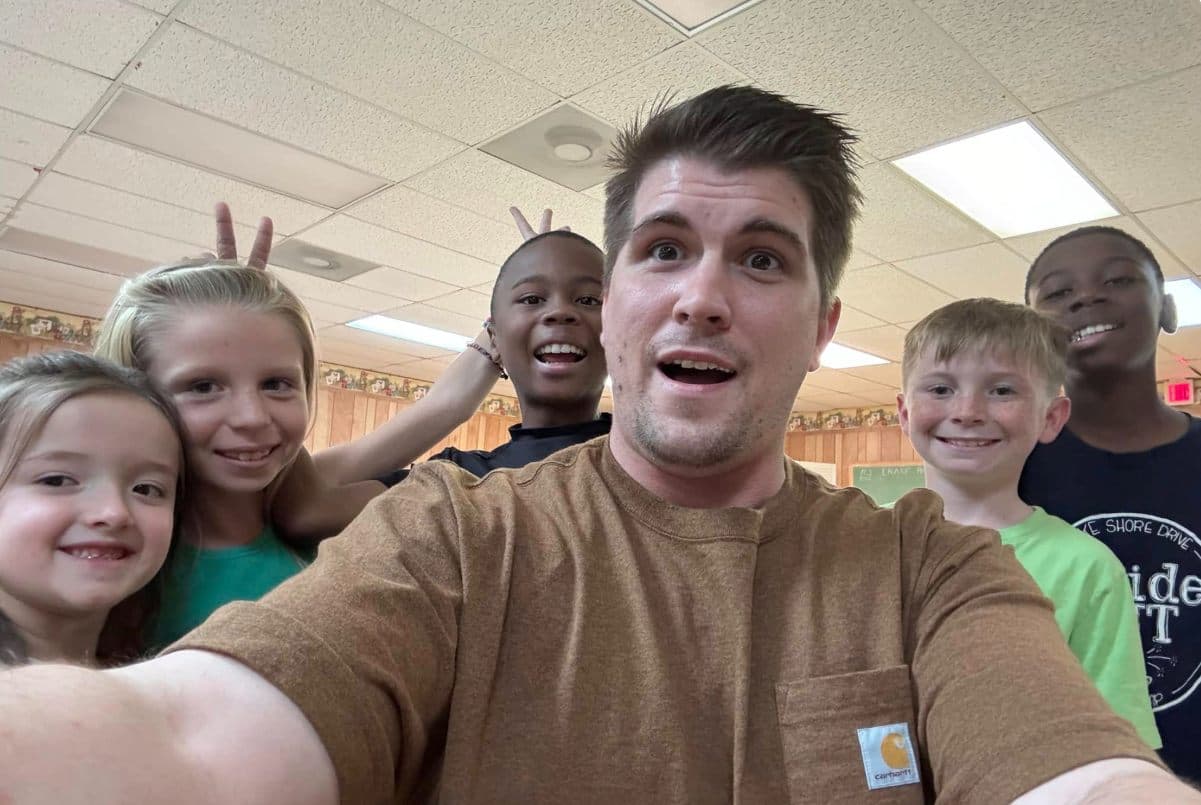 A young member and kids of the congregation grinning for a selfie